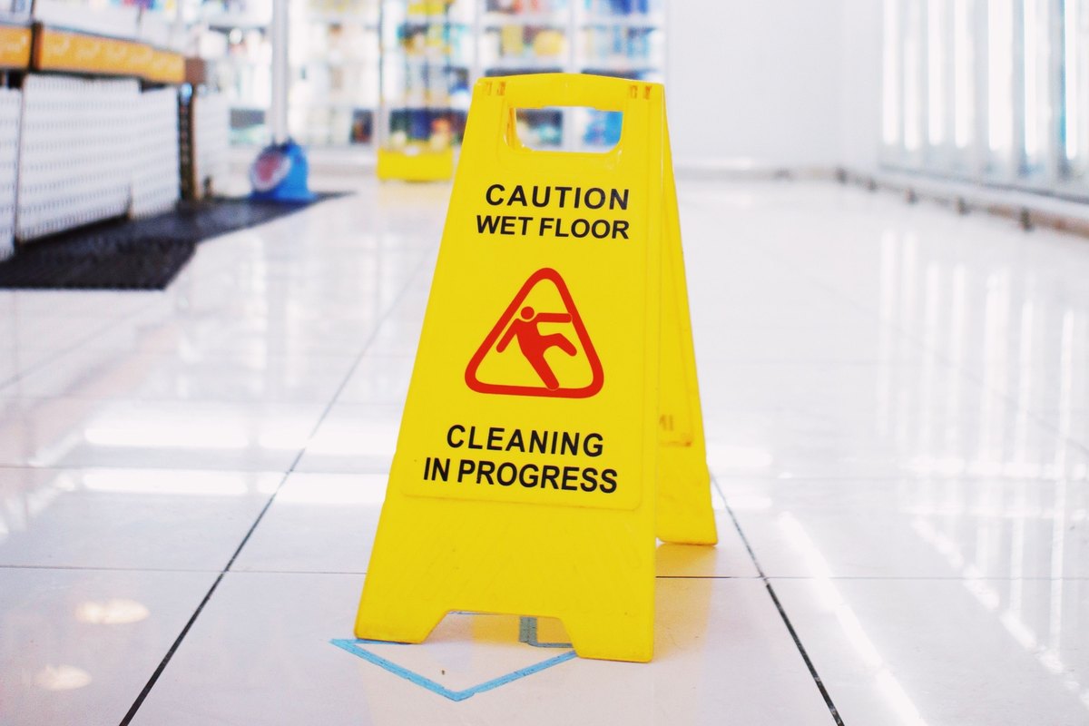 Caution wet floor sign on a glossy white tile floor