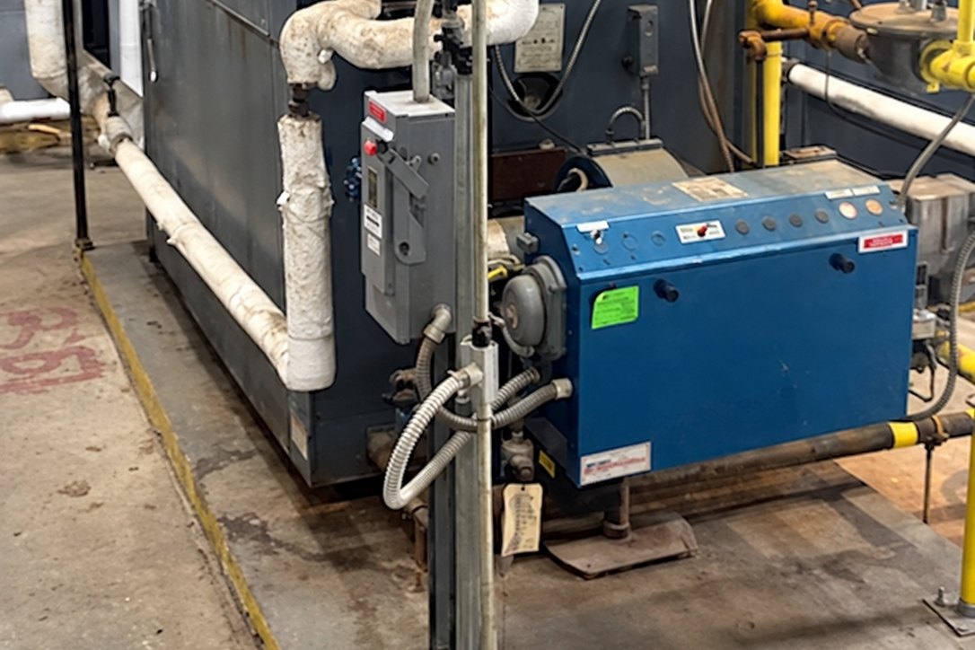 Blue burner unit and controls on a gray commercial boiler