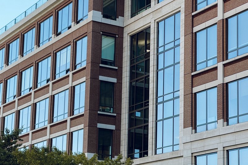 Brick and glass office building with trees at its base