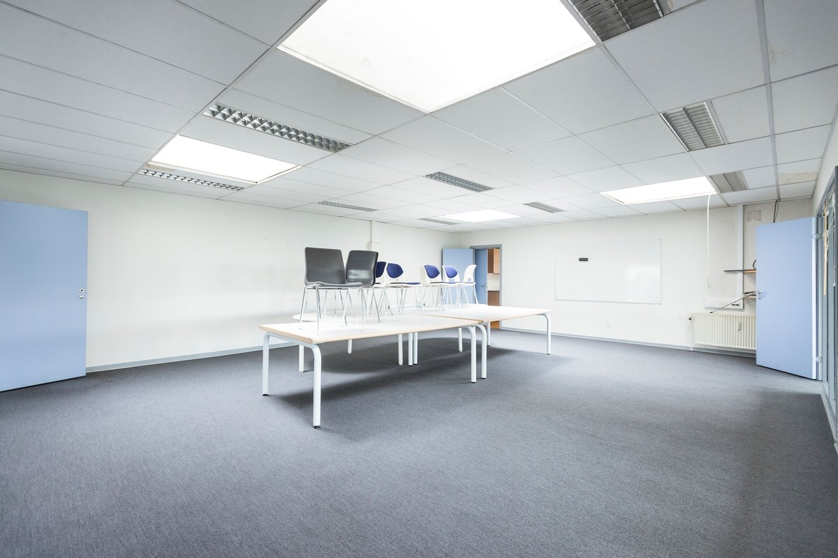 Bright empty meeting room with smooth white walls and recessed lights
