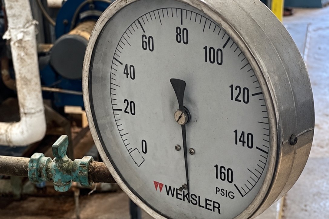 Large pressure gauge on a pipe in a boiler room